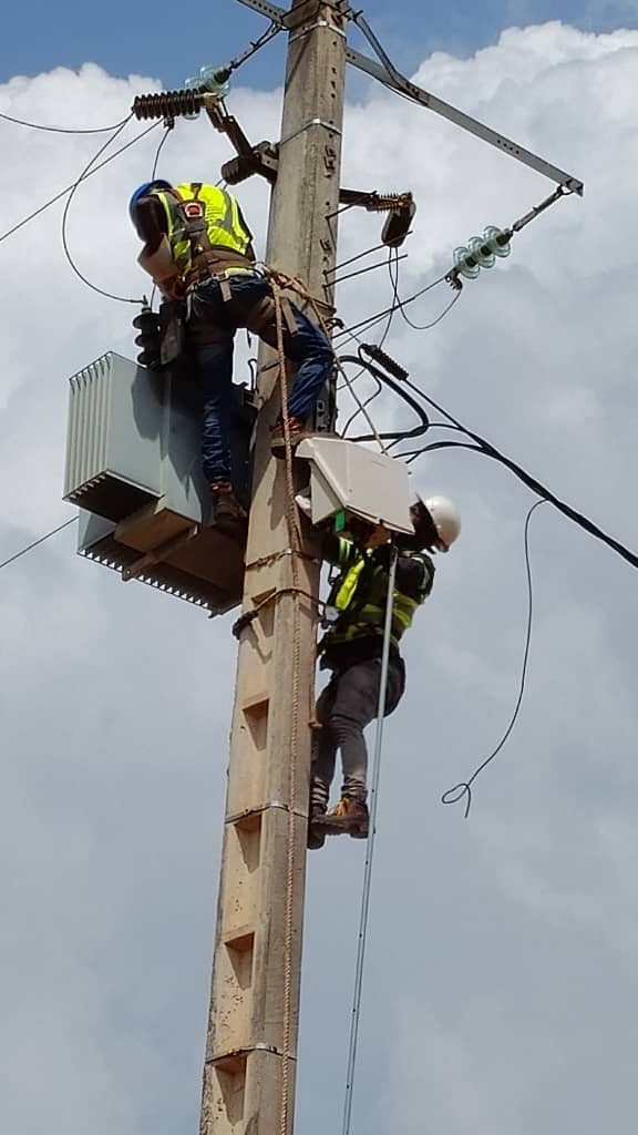 Technicien DIPRESS INTERNATIONAL en intervention sur poteau électrique lors de l'installation d'un poste de transformation à Abidjan