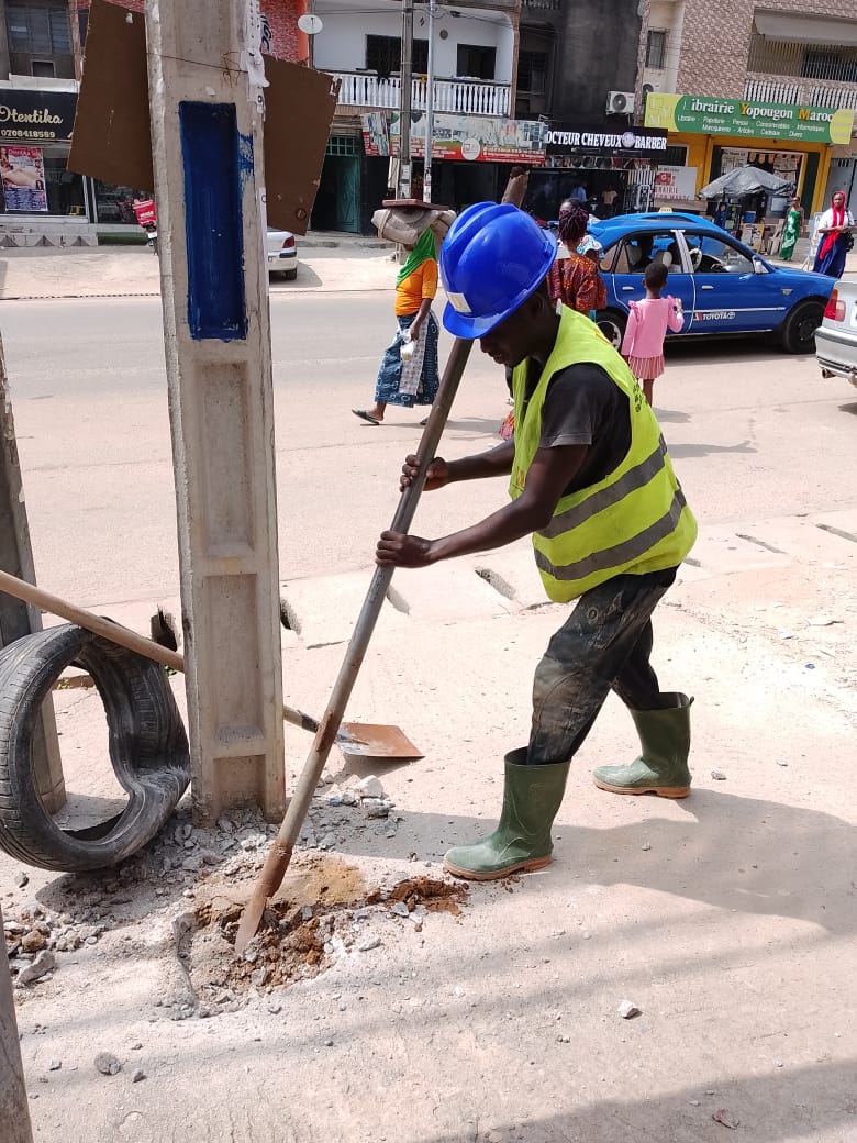 Technicien DIPRESS creusant une fouille pour travaux sur réseau électrique dans une rue d'Abidjan