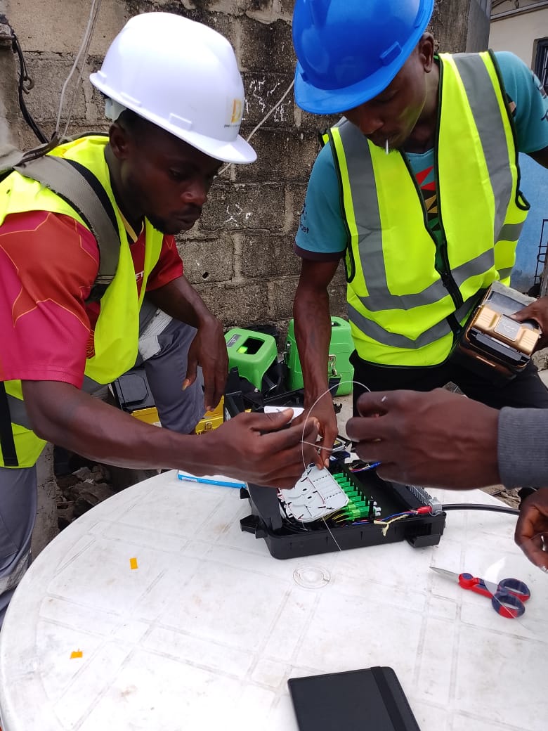 Techniciens DIPRESS INTERNATIONAL réalisant un raccordement de fibre optique sur site